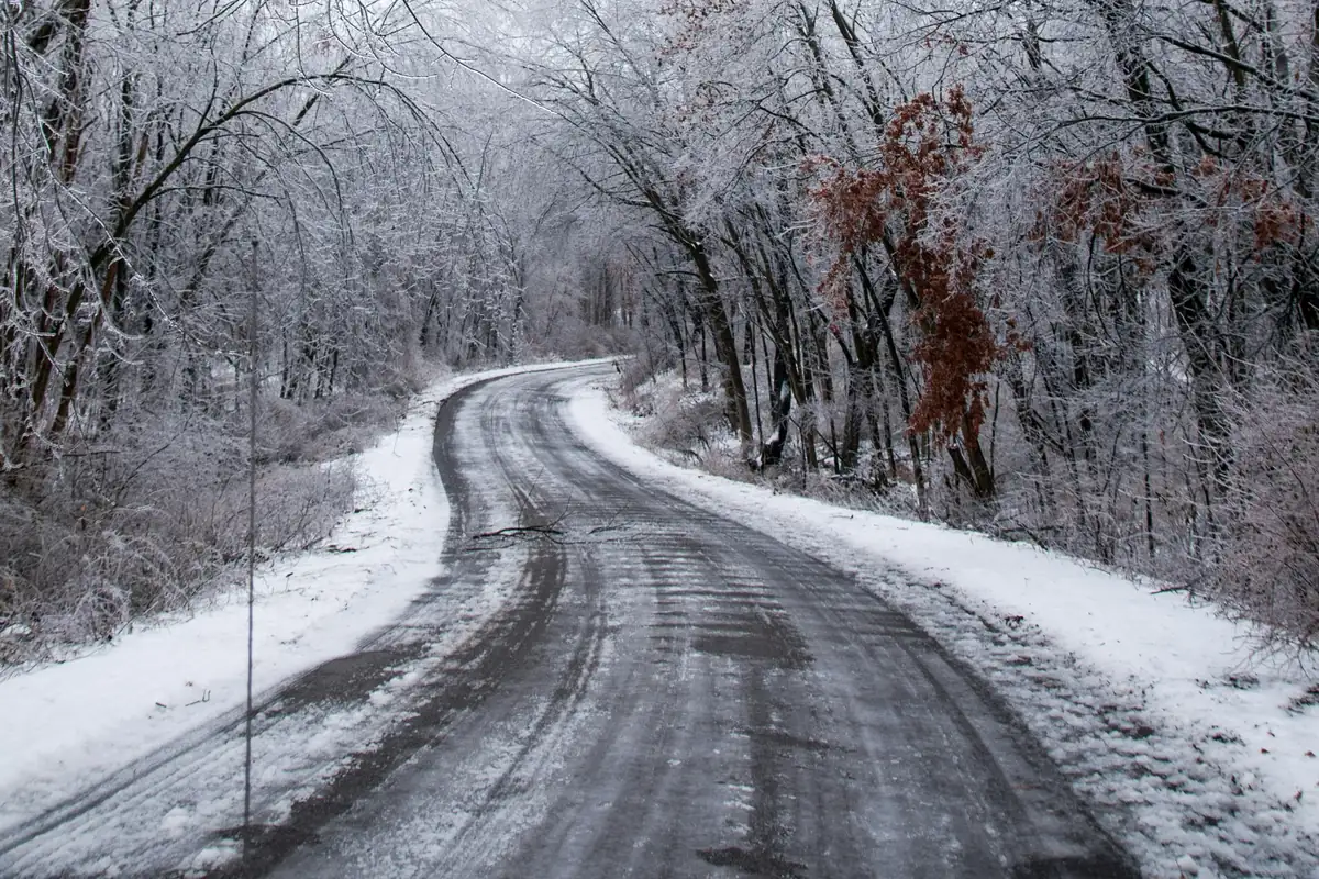 An empty, icy road curving through a Michigan winter.