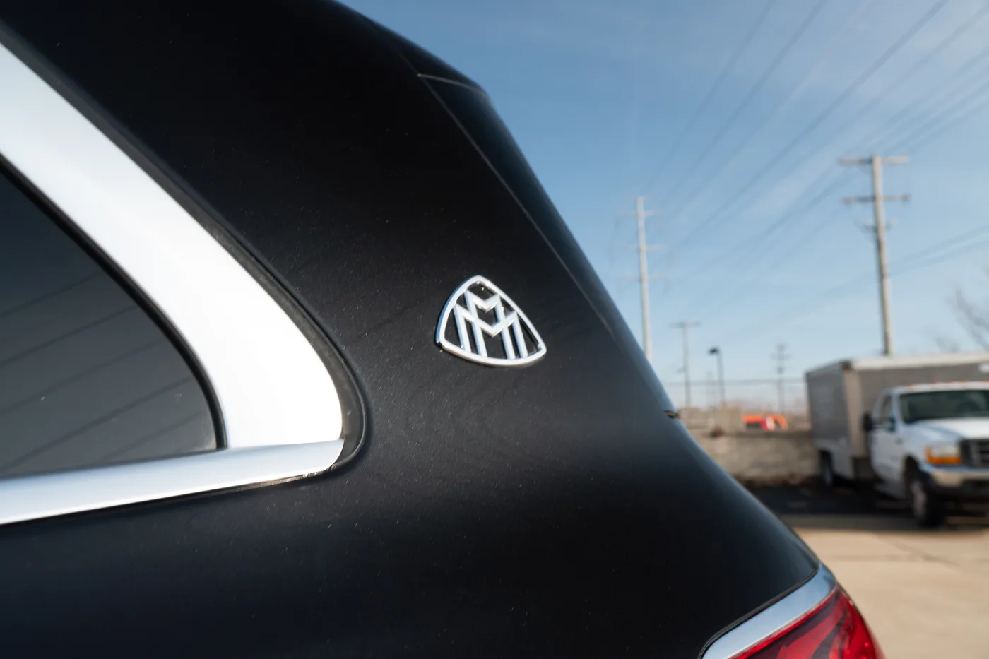 The Maybach emblem on the rear pillar of a black GLS