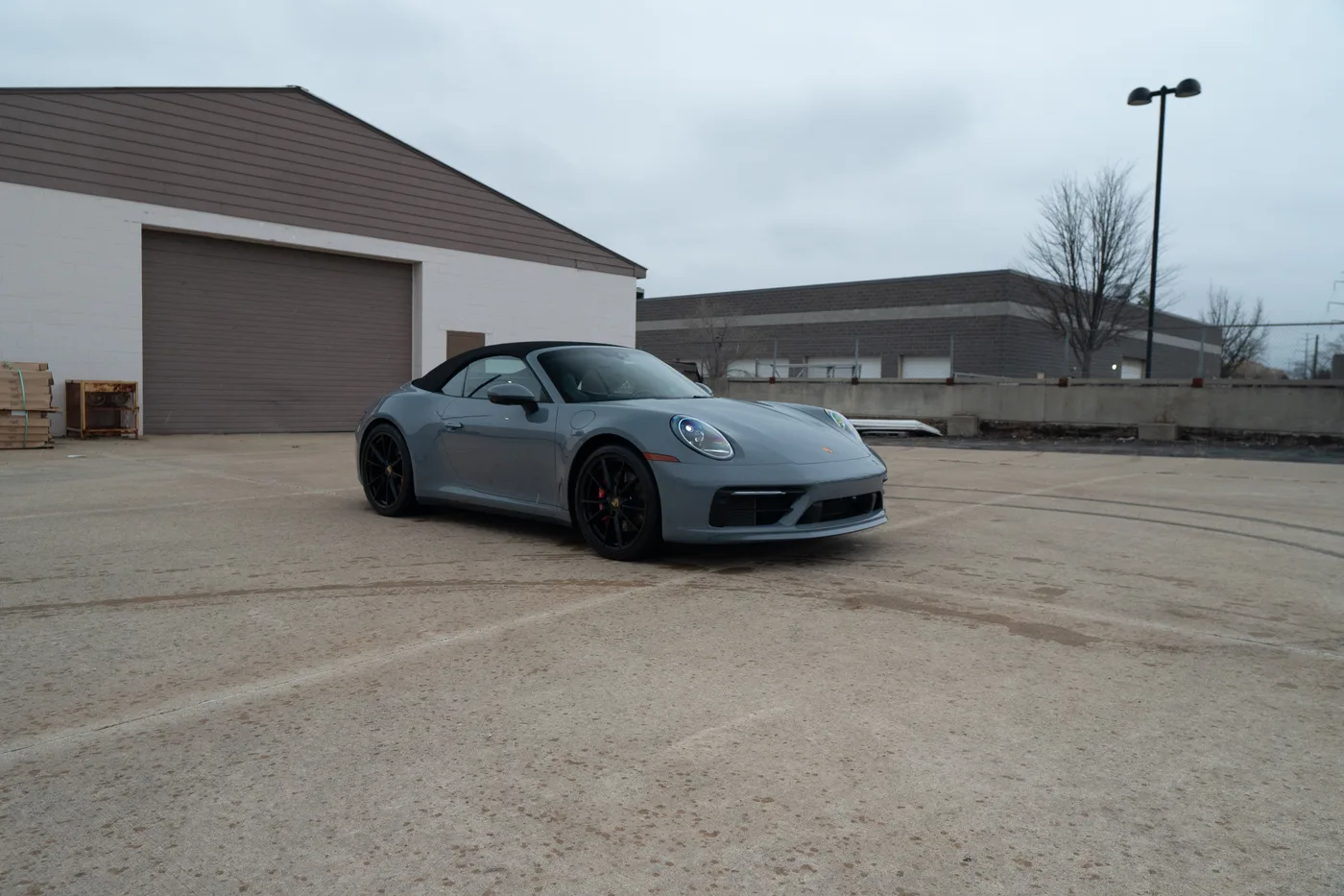 A gray Porsche 911 convertible outside the shop