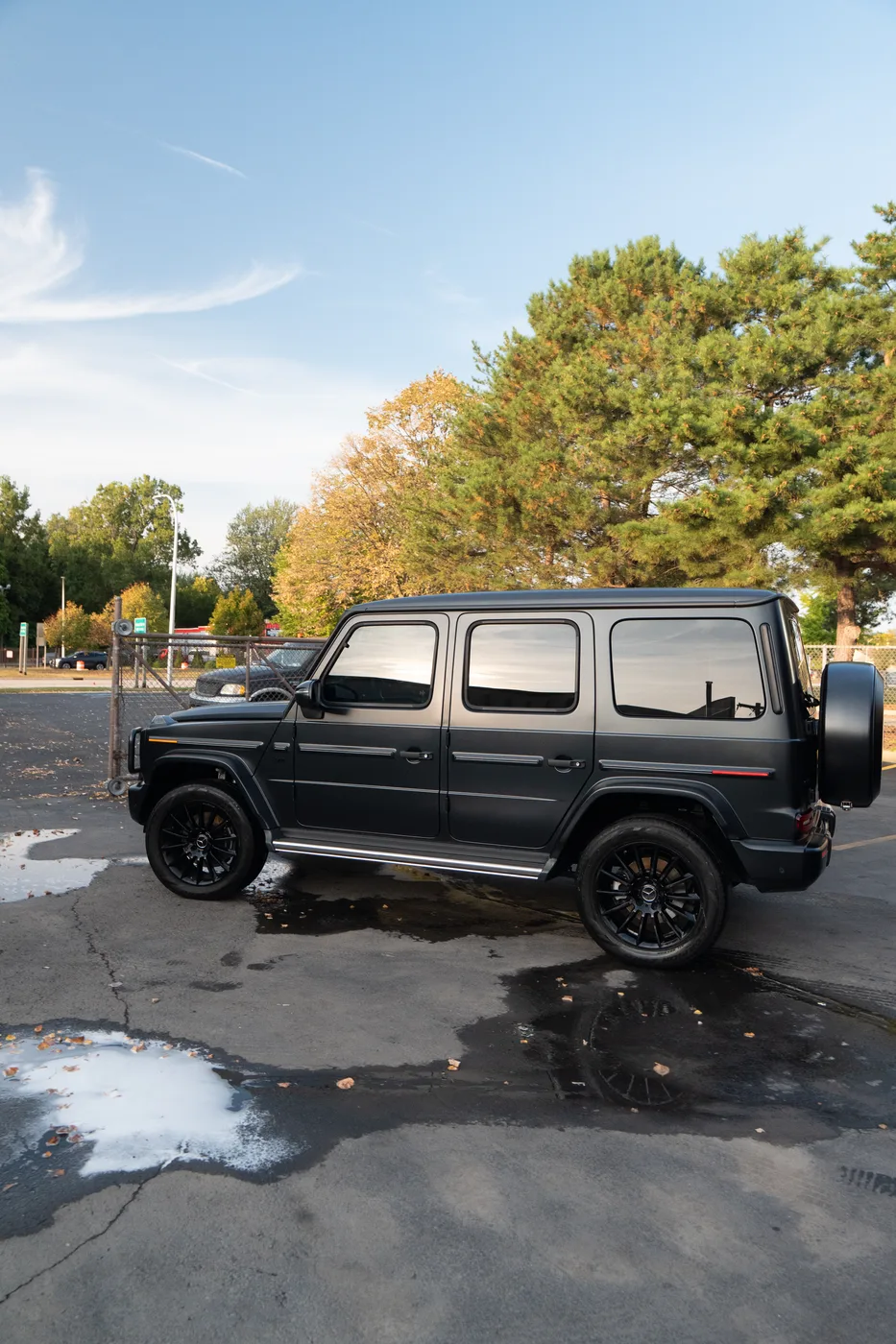 A black Mercedes G-Class on wet pavement