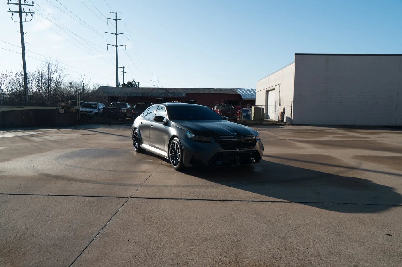 A gray BMW M5 with sharp reflections along its body lines