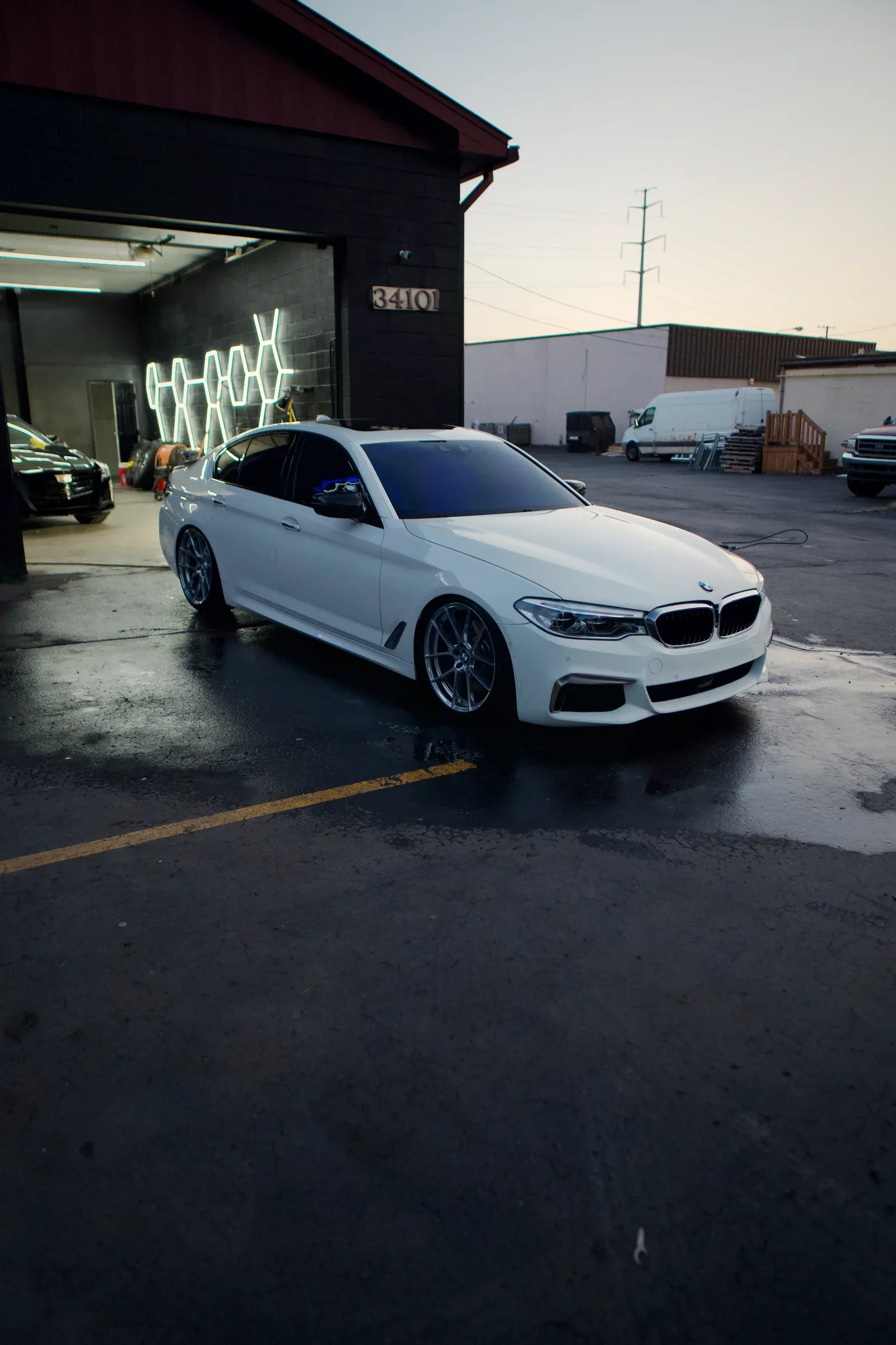 A white BMW 5 Series outside the shop after a full detail