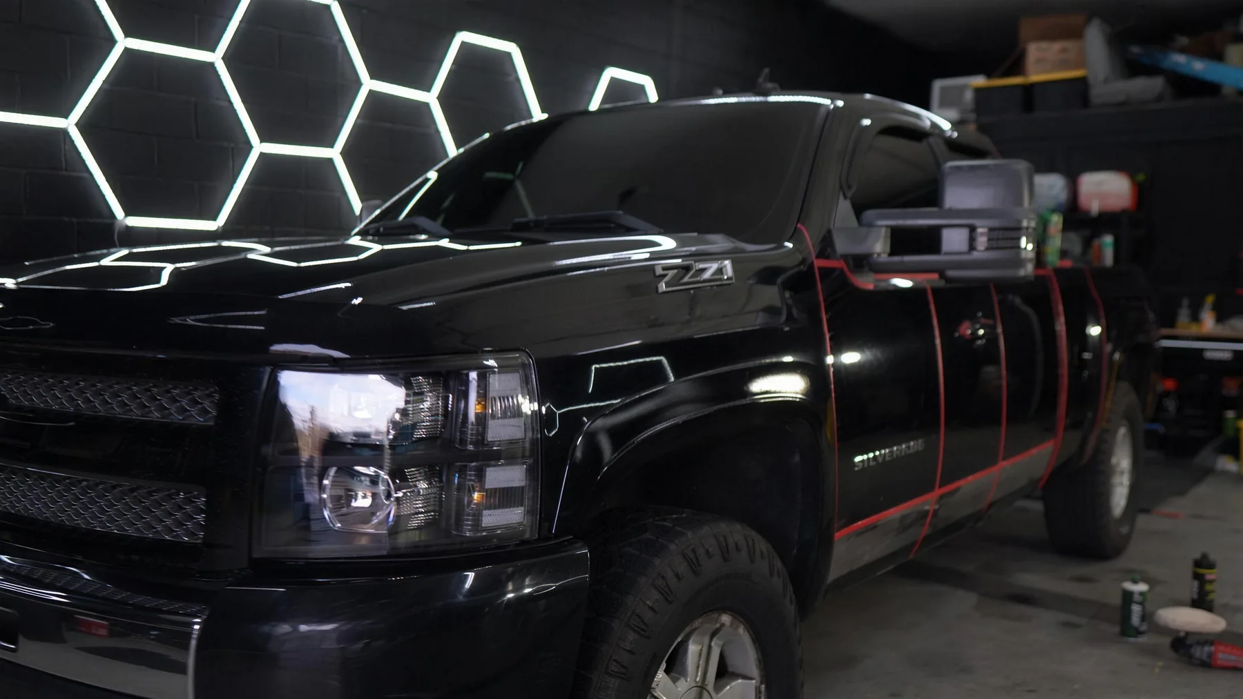 Panels taped into sections during machine paint correction on black paint